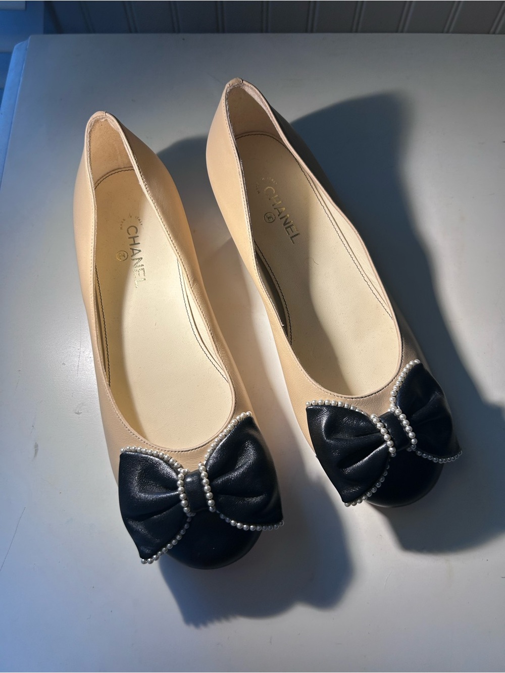 CHANEL Beige and Black Leather Ballet Flats with Pearl-Trim Bow